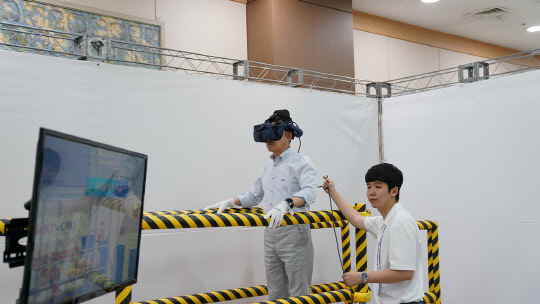 롯데건설 하석주 대표이사가 VR장비를 활용해 비계 추락 상황을 체험 중이다. <롯데건설 제공>